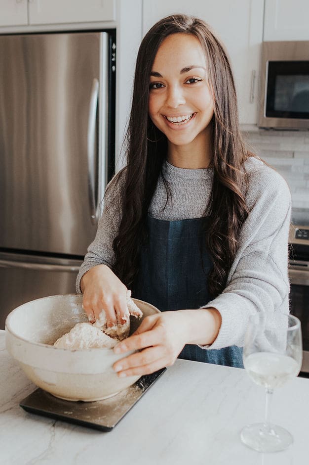 Baker with sourdough bread in ceramic bowl